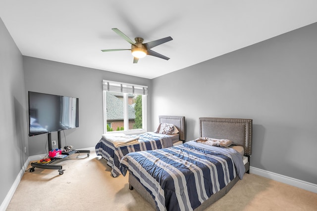 carpeted bedroom with ceiling fan and baseboards