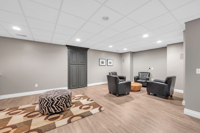 living area featuring recessed lighting, a paneled ceiling, light wood-style flooring, and baseboards