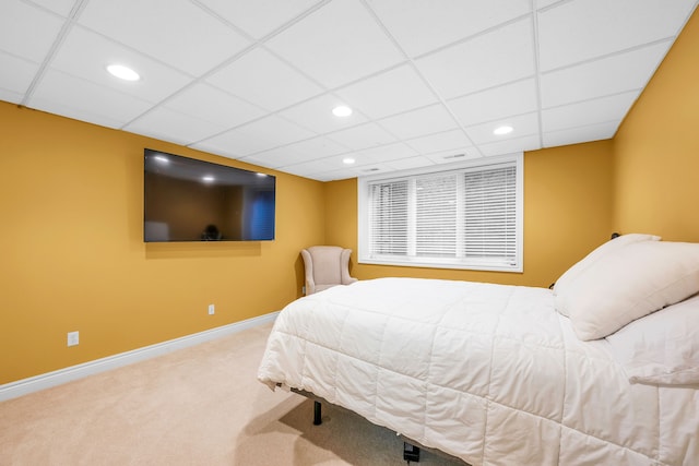 carpeted bedroom with a drop ceiling, recessed lighting, and baseboards