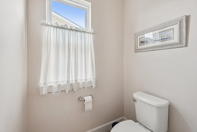 bathroom with baseboards and toilet
