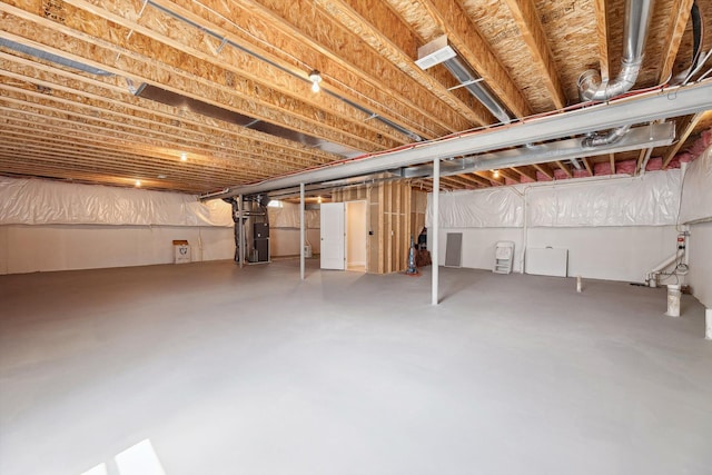 unfinished basement featuring heating unit
