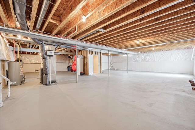unfinished basement featuring heating unit and gas water heater