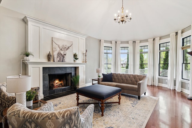 9730 Woodbend Dr, Saline, MI 48176 - living area with a chandelier, baseboards, a tiled fireplace, and wood finished floors