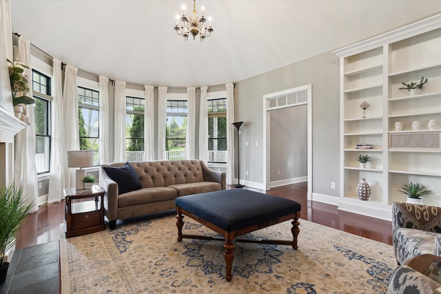 living room with baseboards, wood finished floors, and a chandelier