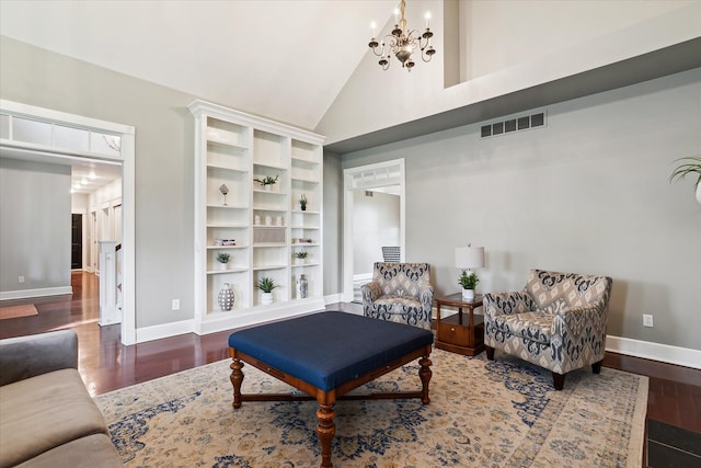 sitting room featuring visible vents, wood finished floors, high vaulted ceiling, baseboards, and an inviting chandelier