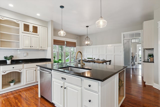 kitchen with dark countertops, open shelves, a sink, tasteful backsplash, and stainless steel dishwasher