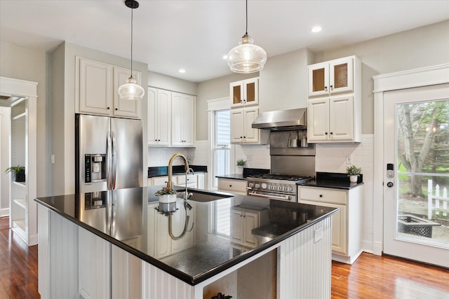 9730 Woodbend Dr, Saline, MI 48176 - kitchen featuring a sink, dark countertops, wall chimney exhaust hood, stainless steel appliances, and plenty of natural light