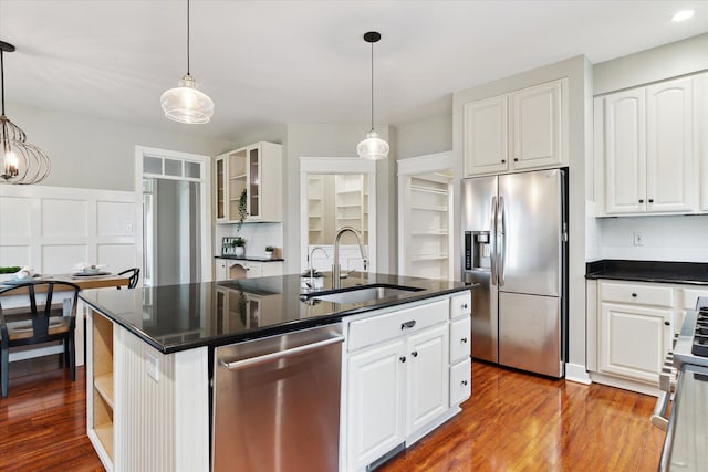 kitchen with a sink, white cabinetry, dark countertops, and stainless steel appliances