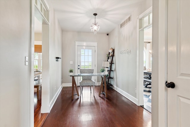 home office featuring an inviting chandelier, baseboards, dark wood-type flooring, and visible vents