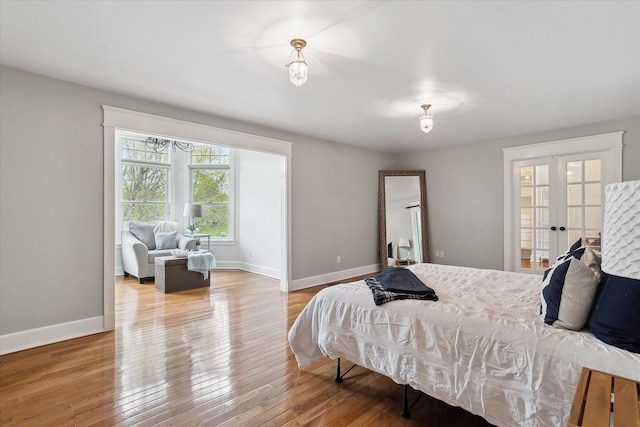bedroom with baseboards, french doors, and hardwood / wood-style floors