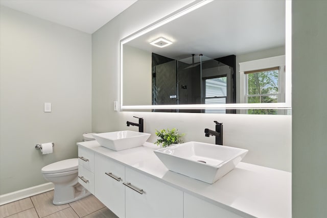 bathroom featuring baseboards, a sink, toilet, and a shower stall