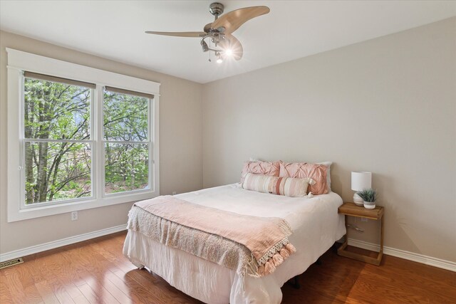 9730 Woodbend Dr, Saline, MI 48176 - bedroom featuring baseboards, visible vents, ceiling fan, and wood finished floors
