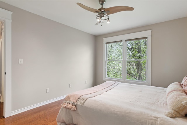 bedroom featuring baseboards, a ceiling fan, and wood finished floors