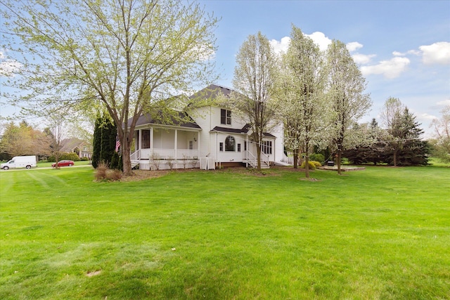 back of house featuring a lawn and covered porch
