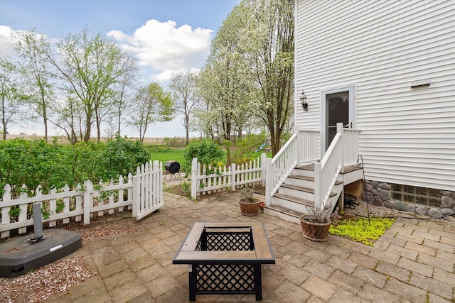 view of patio / terrace featuring fence and a fire pit