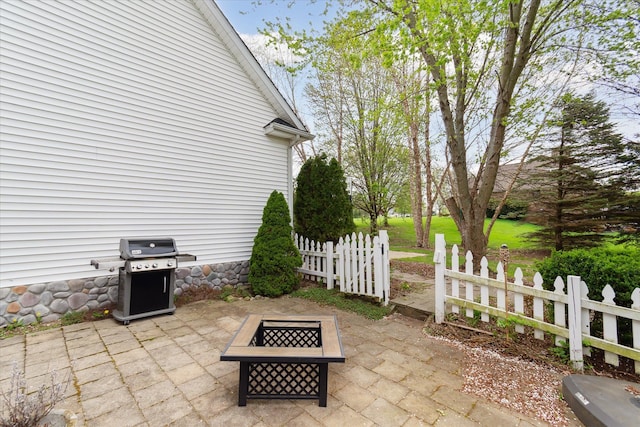 view of patio featuring fence, a grill, and an outdoor fire pit