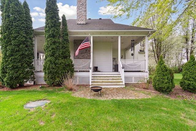 9730 Woodbend Dr, Saline, MI 48176 - view of front of property featuring stone siding, an outdoor fire pit, a chimney, a front yard, and a porch