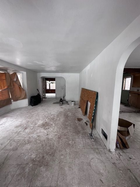 unfurnished living room featuring arched walkways