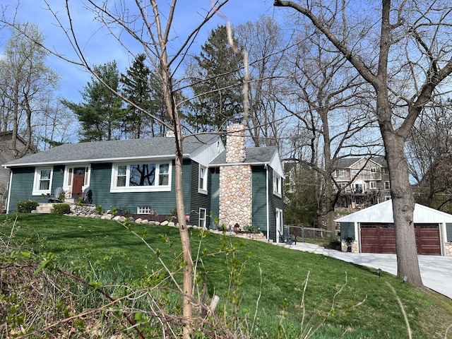 ranch-style home with an outdoor structure, a front yard, a chimney, and a detached garage