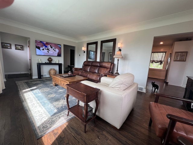 living area featuring dark wood-type flooring, ornamental molding, baseboards, and visible vents