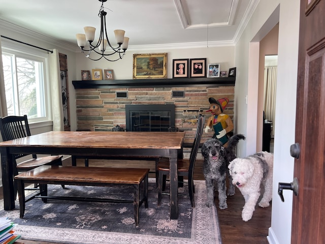 dining space featuring ornamental molding, wood finished floors, attic access, and a fireplace