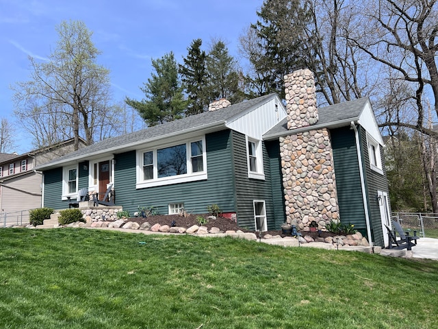 view of front of property with roof with shingles, fence, a chimney, and a front yard