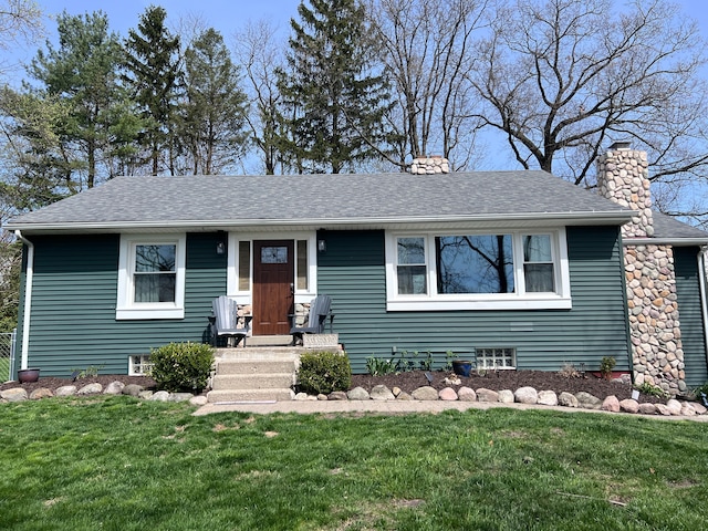 view of front of home featuring a shingled roof, a front lawn, and a chimney