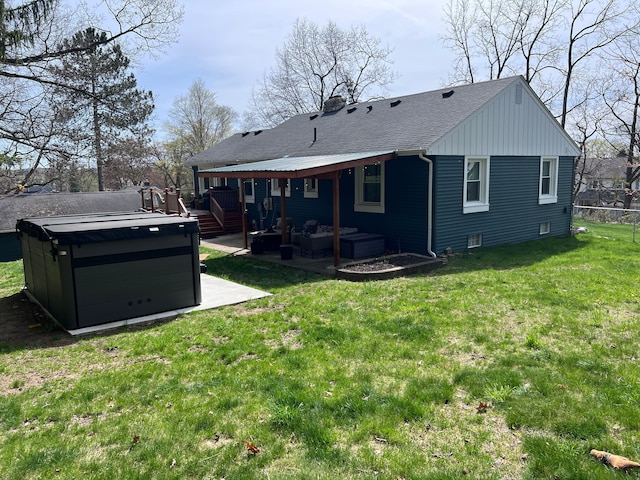 rear view of house with roof with shingles, a hot tub, board and batten siding, a patio, and a yard