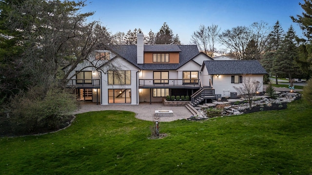 back of property featuring a chimney, a patio area, stairway, and a deck