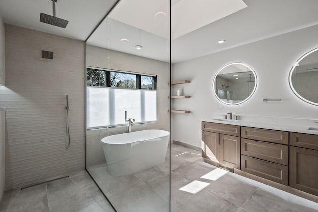 full bath with walk in shower, a sink, double vanity, visible vents, and a soaking tub