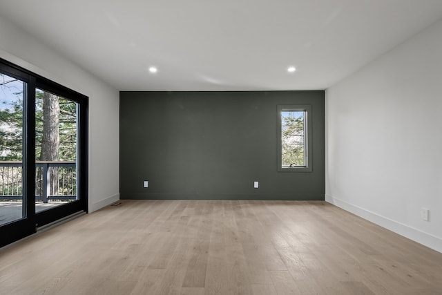 empty room featuring recessed lighting, a healthy amount of sunlight, and light wood-style flooring