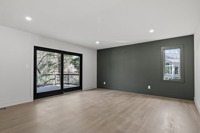 unfurnished room featuring recessed lighting, baseboards, light wood finished floors, and a wealth of natural light