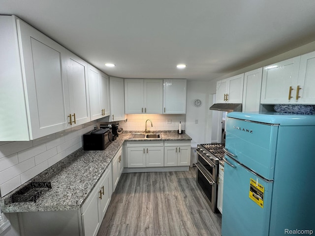 1304 Helen St, Inkster, MI 48141 - kitchen featuring fridge, double oven range, under cabinet range hood, backsplash, and wood finished floors