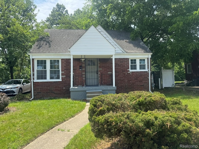 1304 Helen St, Inkster, MI 48141 - bungalow-style home with brick siding, a front lawn, and a shingled roof
