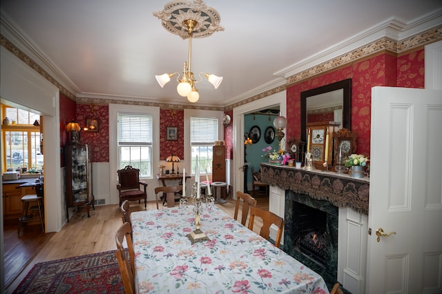 117 Bradley St, Romeo, MI 48065 - dining area featuring a chandelier, light wood-style floors, a wainscoted wall, ornamental molding, and wallpapered walls