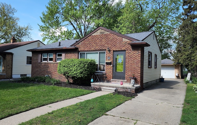 view of front of house featuring a front yard, brick siding, an outbuilding, roof with shingles, and a garage