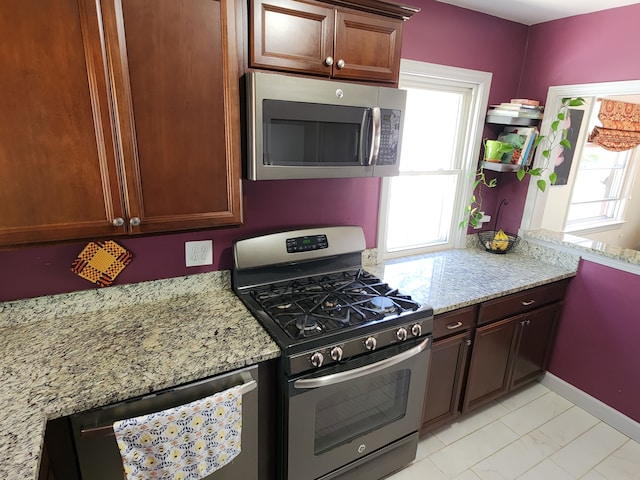 kitchen with stainless steel appliances and light stone countertops