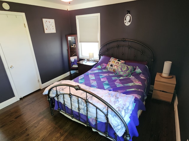 bedroom with dark wood finished floors and baseboards