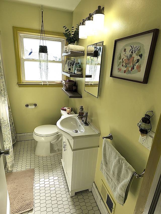 bathroom with vanity, toilet, tile patterned flooring, and baseboards