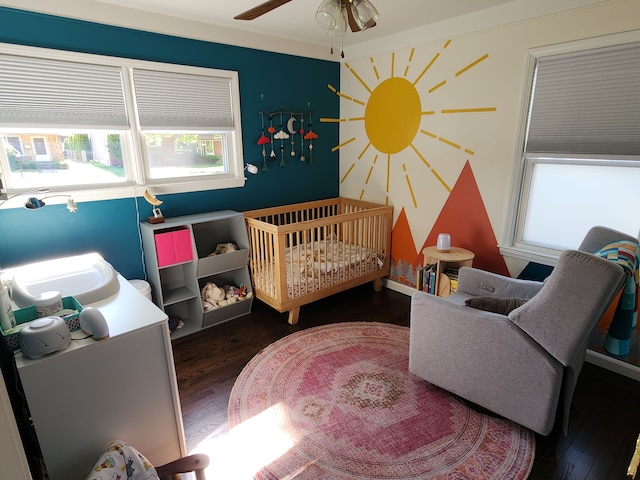 bedroom featuring wood finished floors and a crib