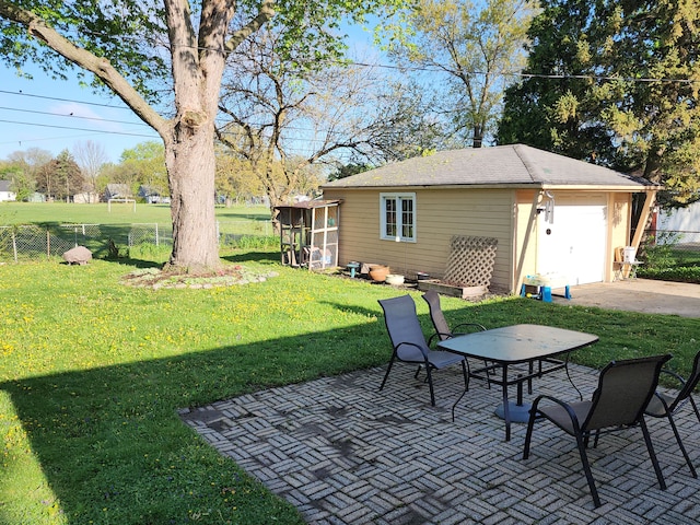view of yard with a patio area, an outdoor structure, and a detached garage