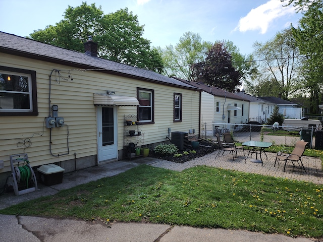 back of house featuring a patio, a chimney, and central air condition unit