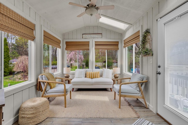 sunroom / solarium with lofted ceiling with skylight, a wealth of natural light, and wood finished floors