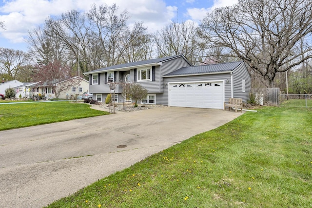 raised ranch featuring a front yard, a garage, metal roof, driveway, and fence