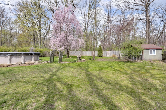view of yard featuring fence and a covered pool