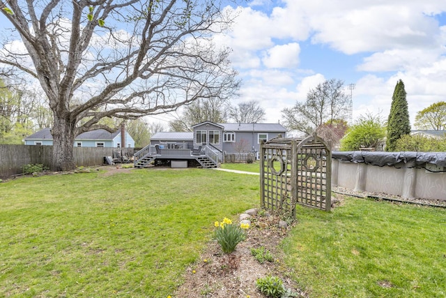 view of yard featuring fence, stairway, a deck, and a fenced in pool