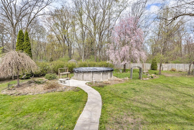 view of yard with fence and a fenced in pool