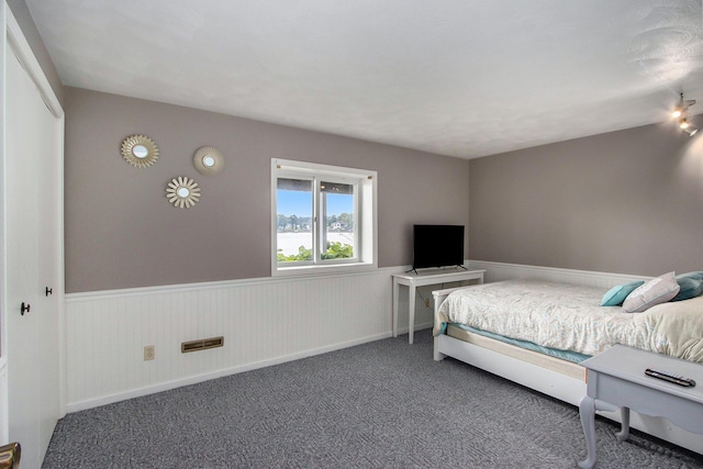 bedroom featuring carpet and wainscoting