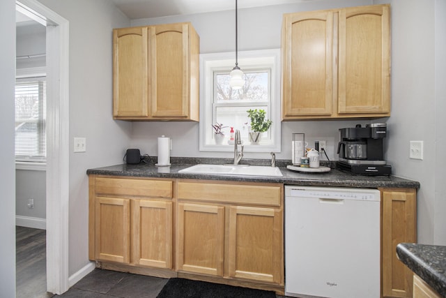 kitchen featuring light brown cabinetry, white dishwasher, dark countertops, a sink, and a healthy amount of sunlight