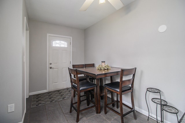 dining space featuring a ceiling fan, baseboards, and tile patterned flooring
